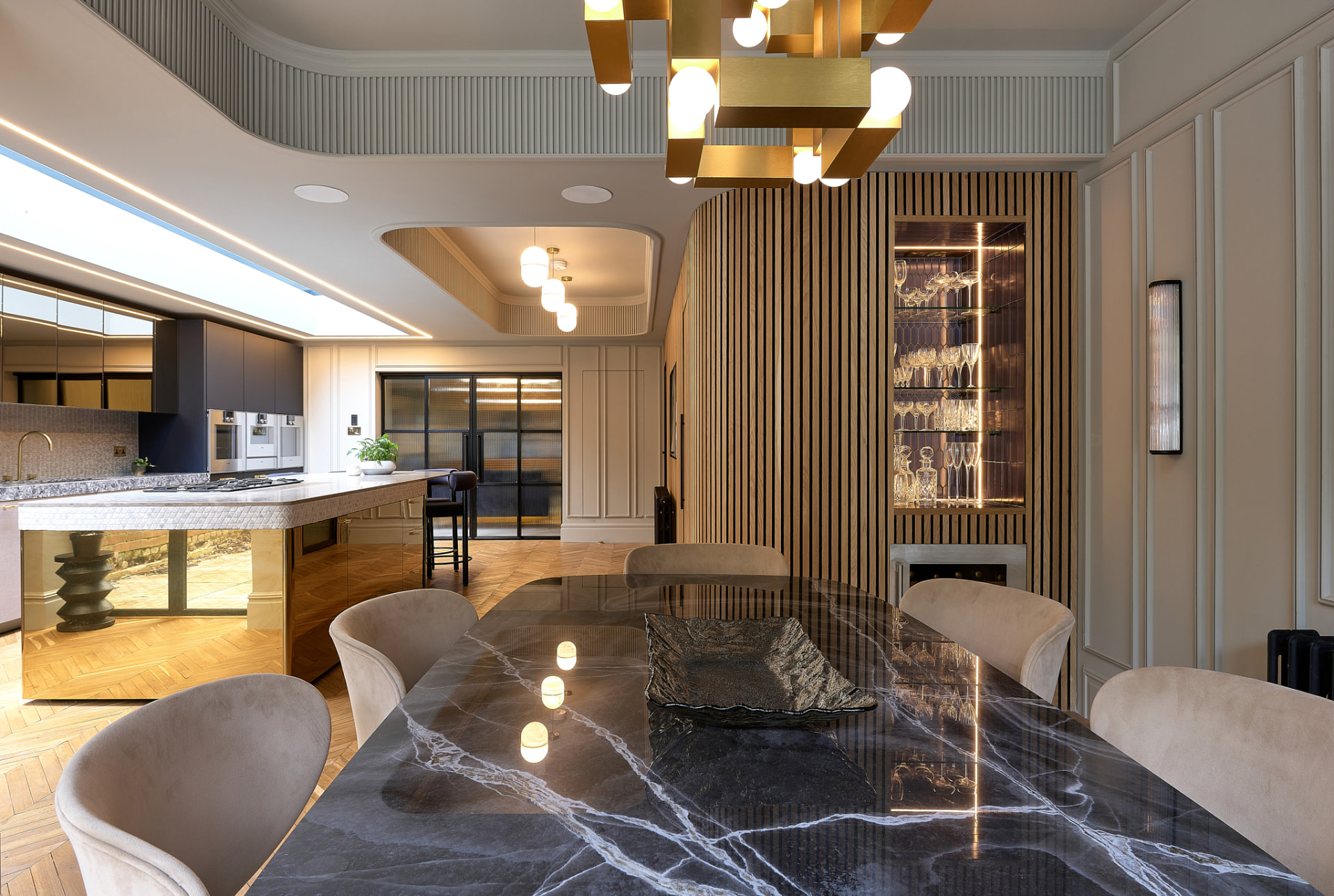 The Townhouse — dining room with marble table, fluted timber and sculptural brass chandelier